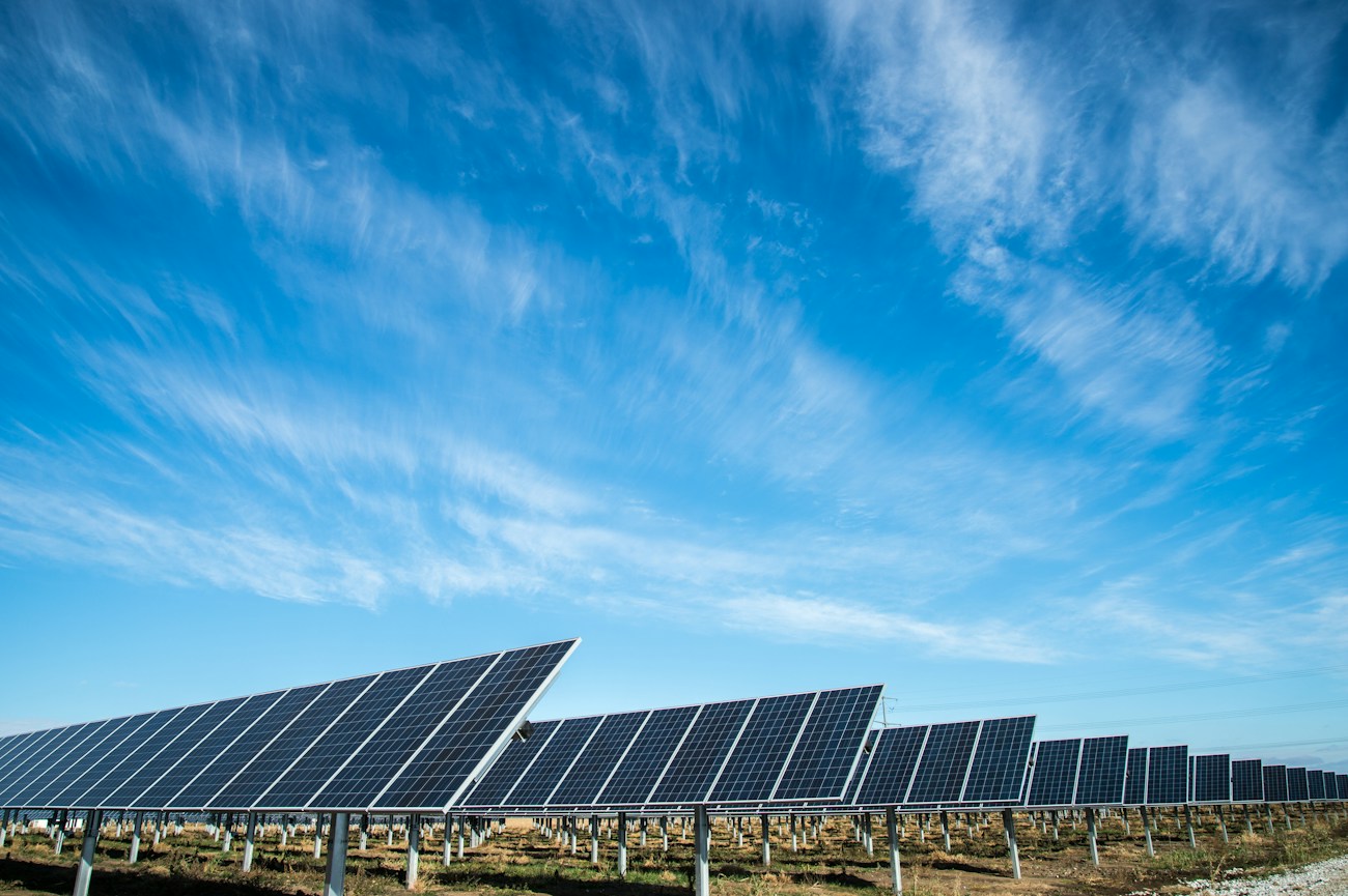 Rows of solar panels under an open blue sky